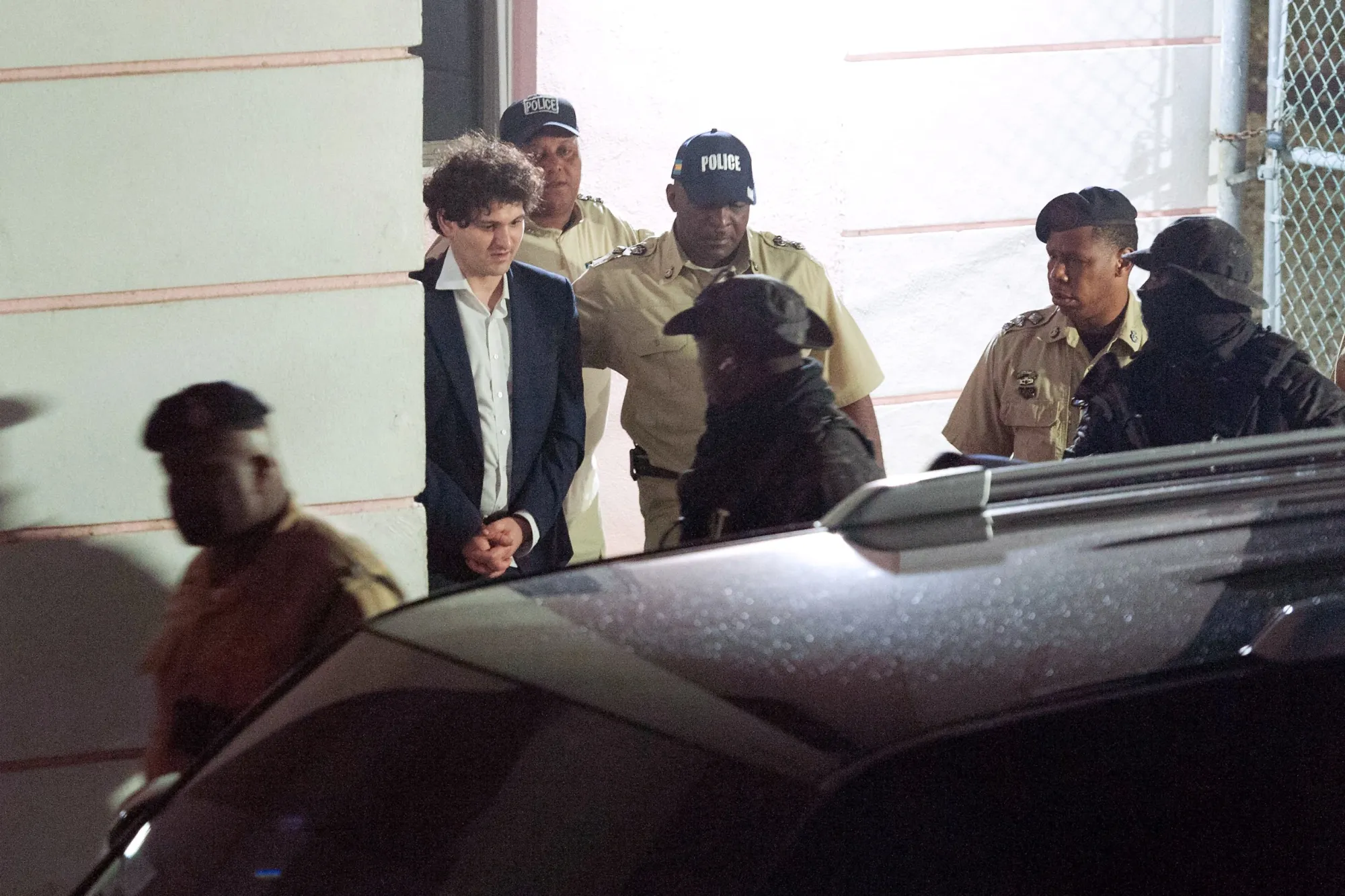 FTX’s Sam Bankman-Fried is led away in handcuffs by police in Nassau, Bahamas, on Dec. 13, 2022.