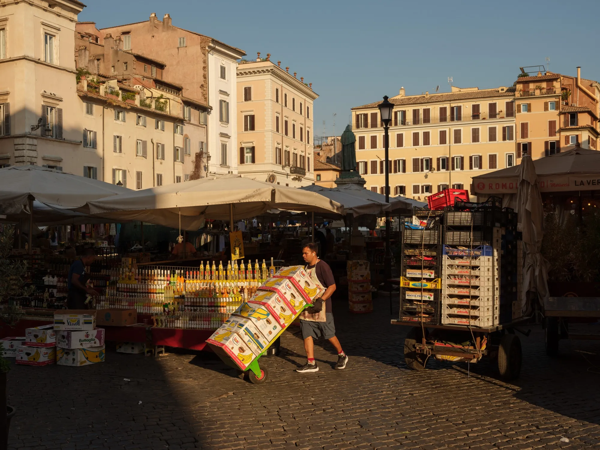 A worker pushes a trolley with boxes of bananas at the Campo de' Fiori fruit and vegetables outdoor market in Rome.
