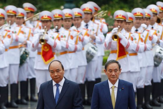 Japan’s Suga Lands Defense Deal With Vietnam Amid China Tension