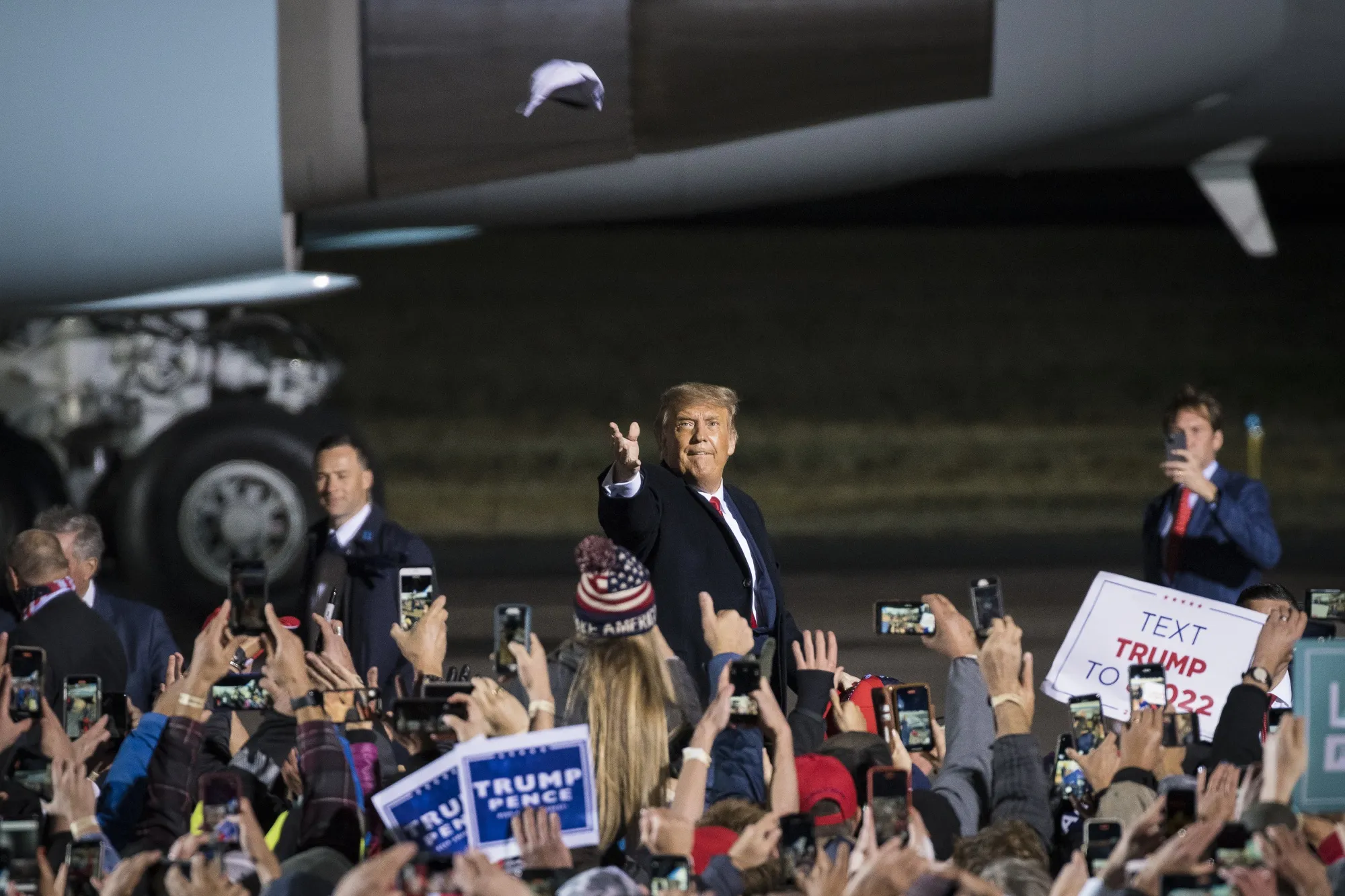 U.S. President Donald Trump tosses a cap at attendees at a rally in Duluth, Minnesota on Sept. 30.