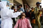 A health worker takes a swab sample from a passenger at a bus station in Ahmedabad on June 8.