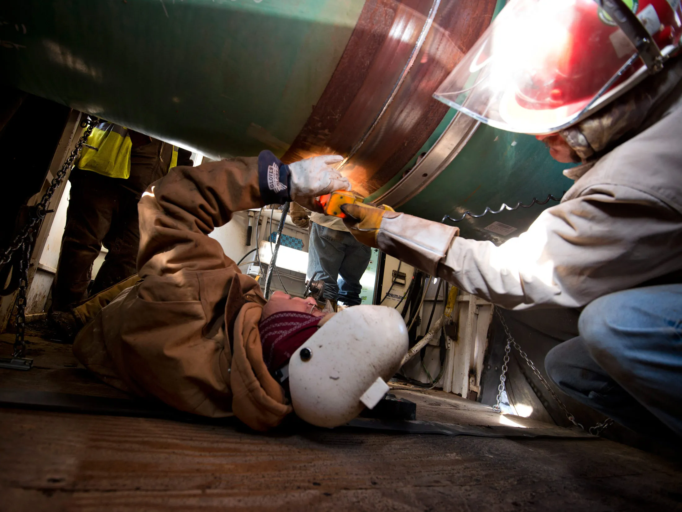Workers inspect a weld on the joint between two sections of pipe on a Gulf Coast Project pipeline in Atoka, Oklahoma.
