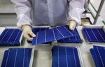 An employee inspects&nbsp;solar cells at the Trina Solar factory in Changzhou, China.&nbsp;
