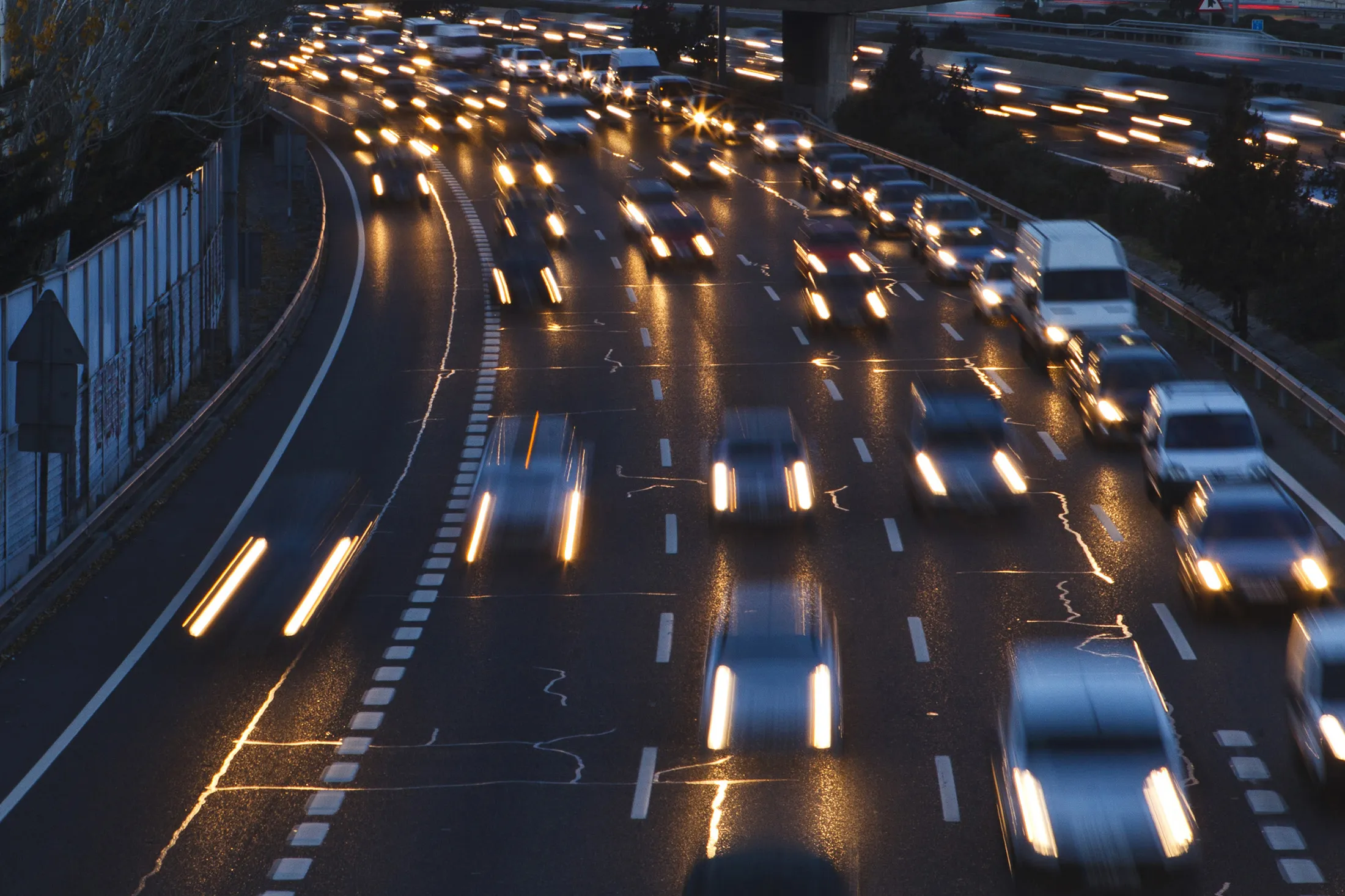 Headlights from passing traffic illuminate a highway at night in Madrid, Spain.