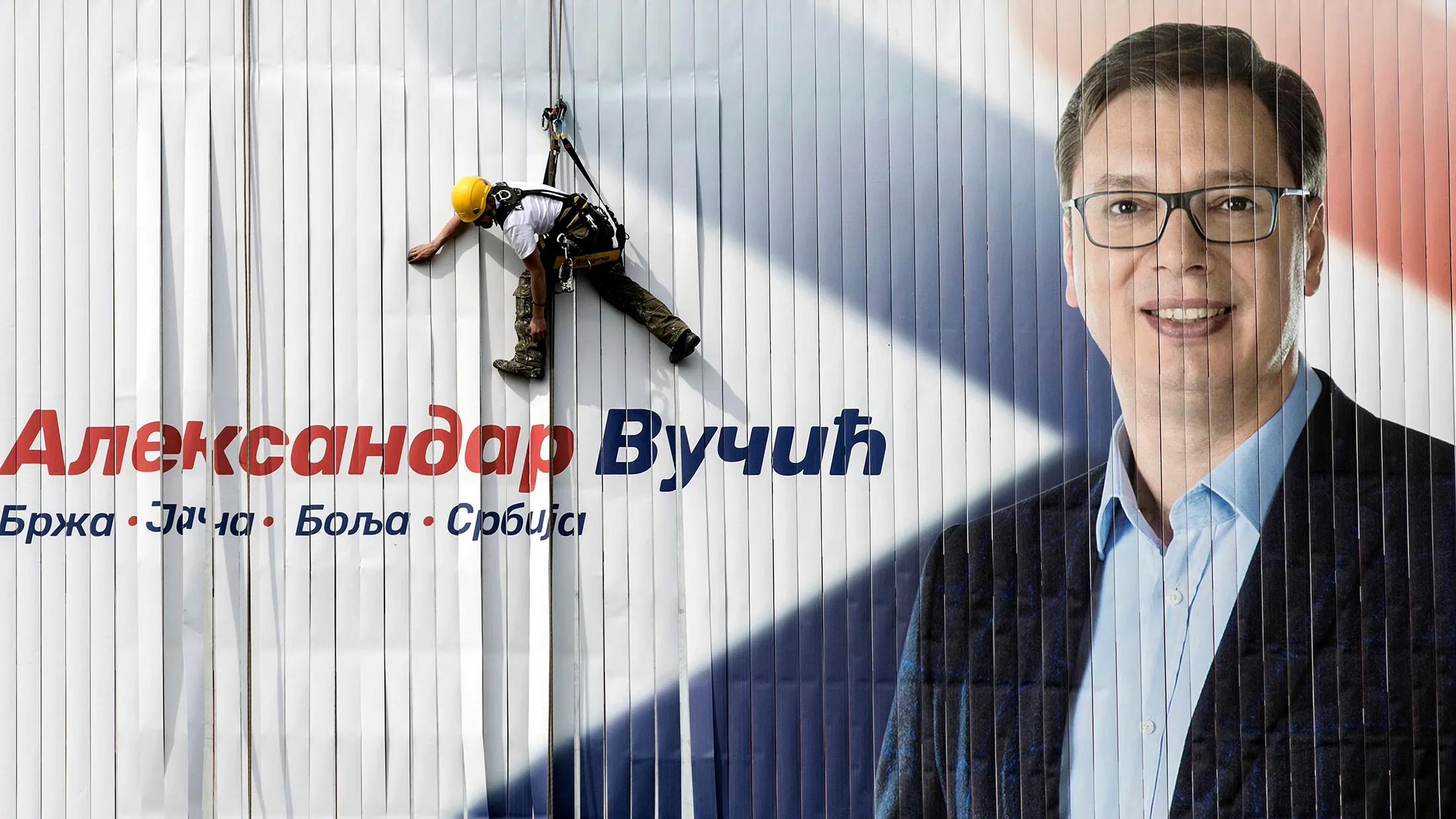 A worker installs on a wall an electoral poster of the Serbian Progressive Party (SNS) top candidate for the presidential election and Serbian Prime Minister Aleksandar Vucic in Belgrade on March 23, 2017. Serbia's strongman Aleksandar Vucic hopes to win presidential elections in the first round on April2, 2017, to strengthen his political power despite criticism from divided opposition accusing him of authoritarianism. / AFP PHOTO / OLIVER BUNIC (Photo credit should read OLIVER BUNIC/AFP/Getty Images)
