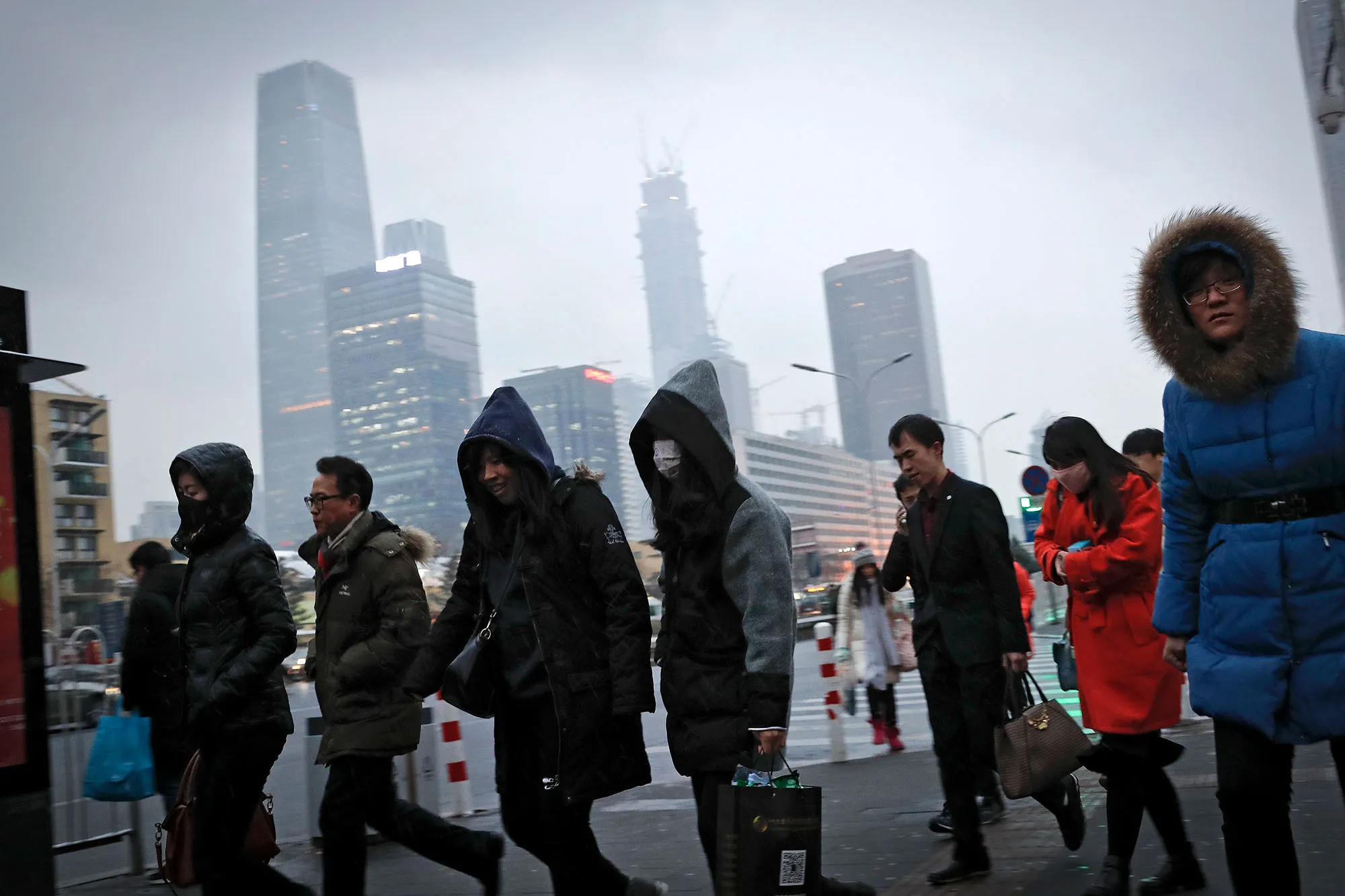 Commuters, some wearing masks walk to a subway station during the evening rush hour in Beijing, on Feb. 21.
