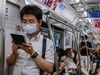 Commuters wearing face masks travel on a train in Tokyo.
