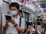 Commuters wearing face masks travel on a train in Tokyo.