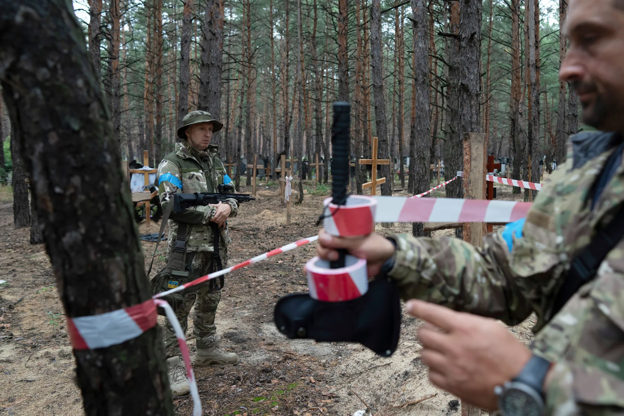 Investigators at the site of the unidentified graves in Izyum, Ukraine, on Sept. 15.