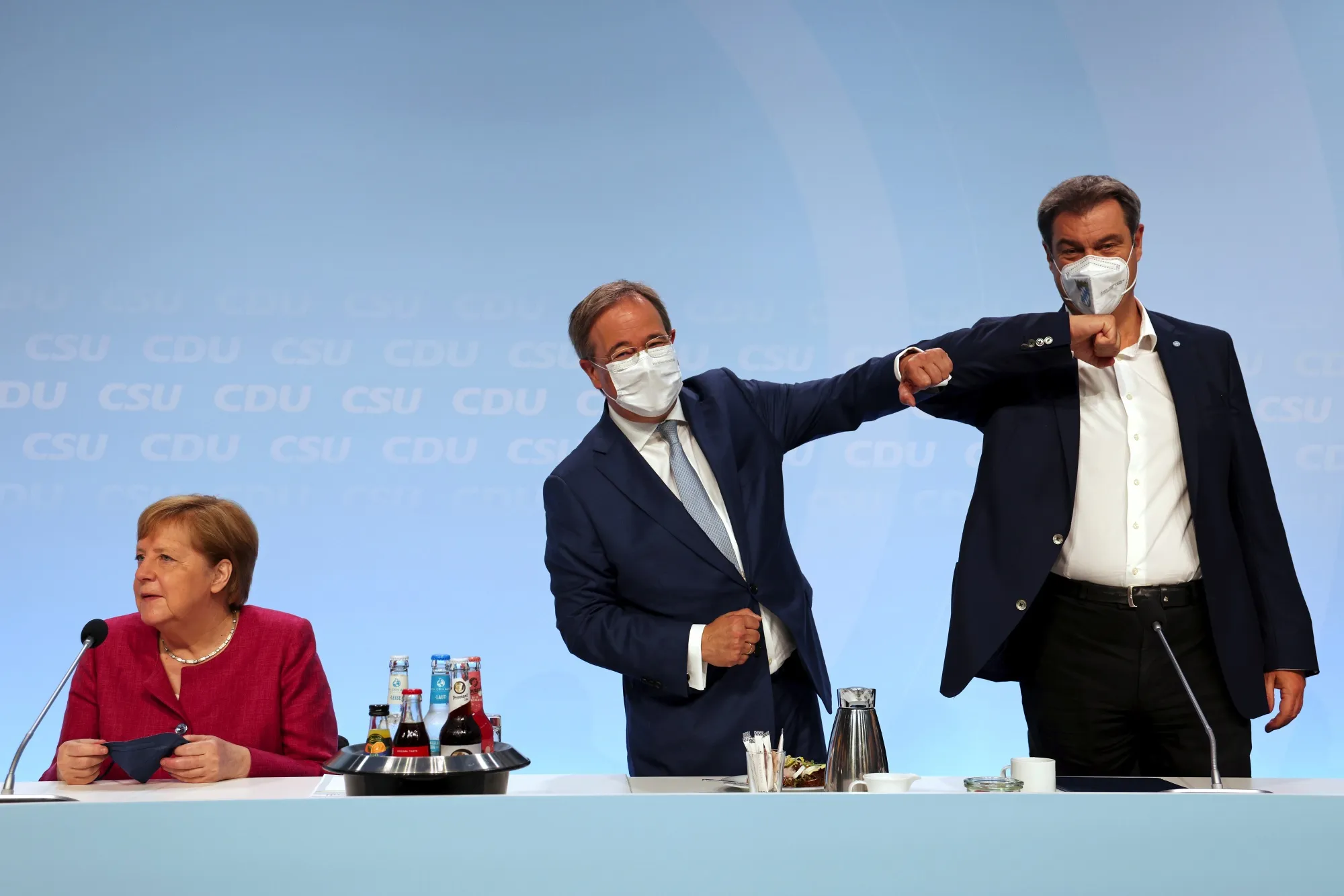 Armin Laschet, center, and Markus Soeder, 'elbow bump' beside Angela Merkel, during the launch of the CDU and CSU election manifesto in Berlin, on June 21.