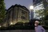 A pedestrian wearing a protective face mask walks past the Bank of Japan (BOJ) headquarters at dusk in Tokyo, Japan.