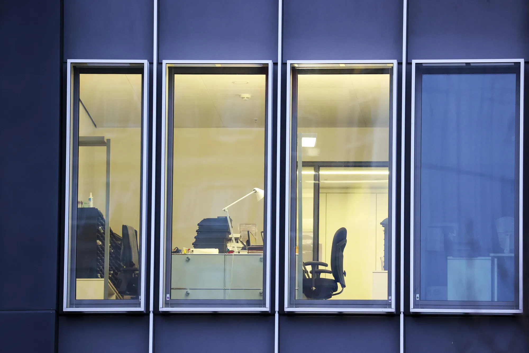 Lights illuminate an empty office space.