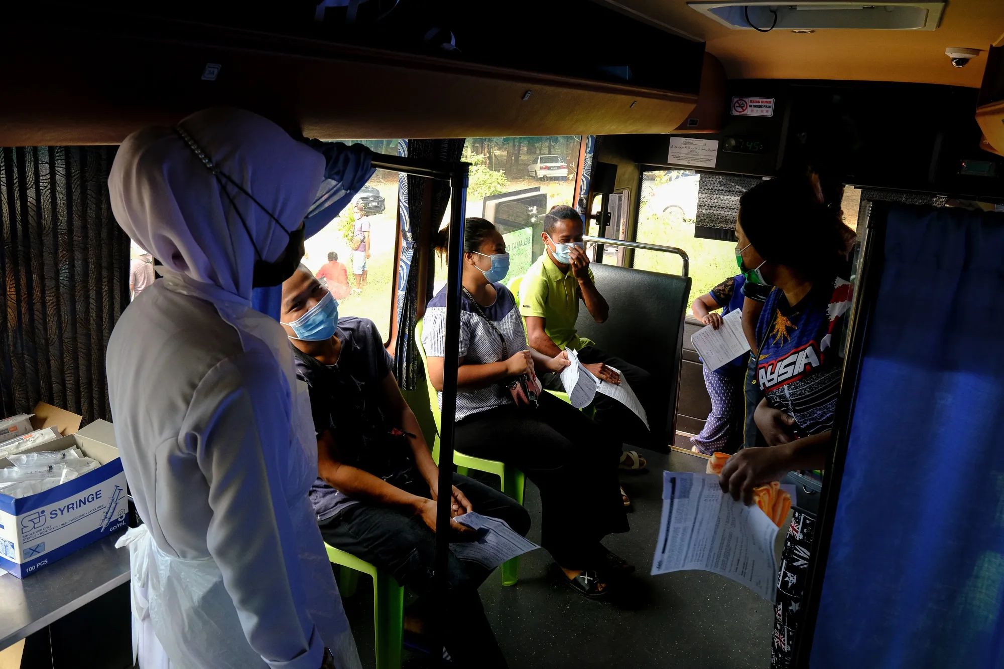 Residents wait to receive the Pfizer-BioNTech Covid-19 vaccine at a mobile vaccination clinic set up at Kampung Bukit Perah in Kuala Langat, Selangor, Malaysia.