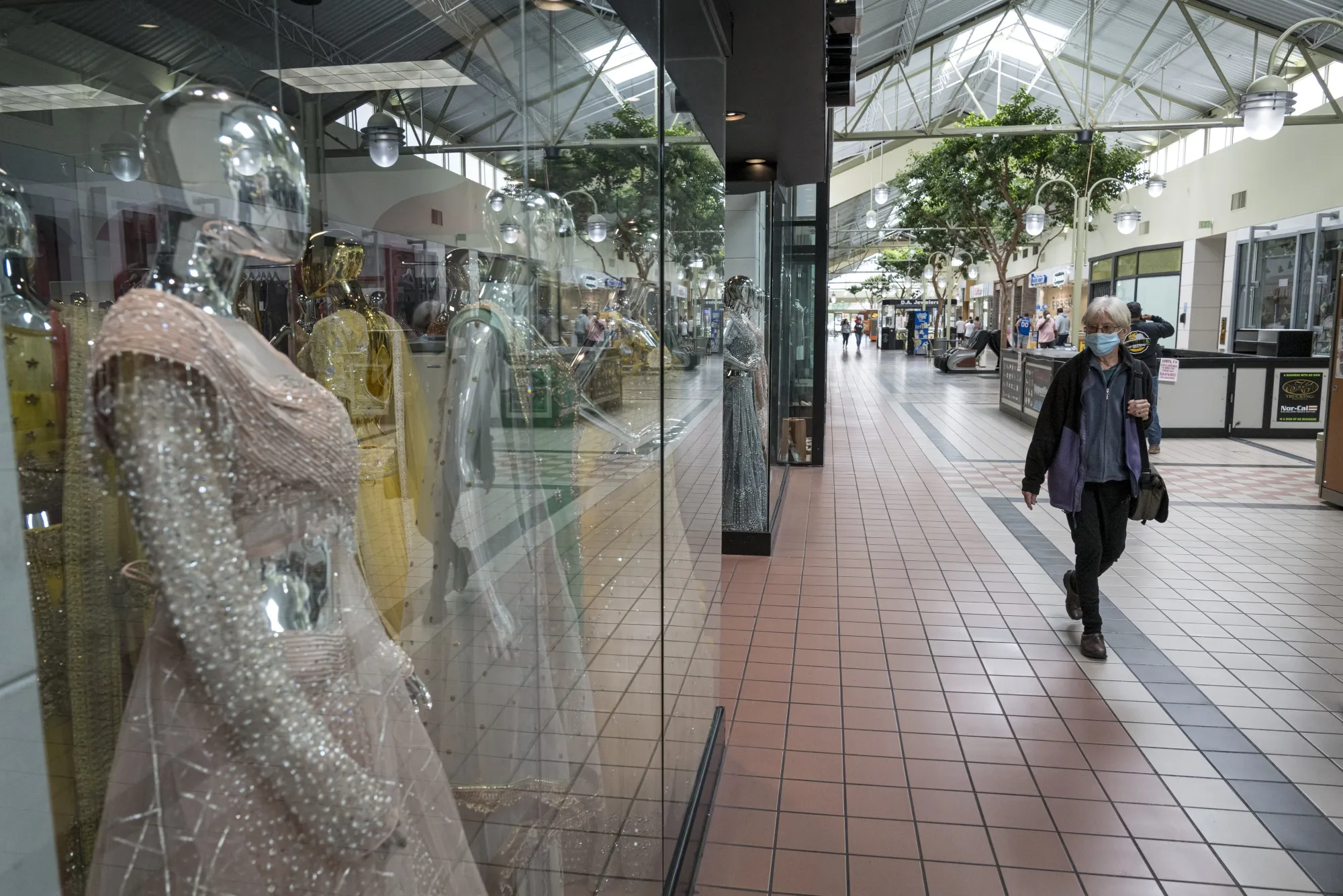 A person wearing a protective mask walks inside the Yuba Sutter Mall in Yuba City, California on May 13.