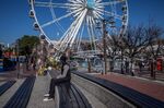 A pedestrian sits on a bench at the Victoria & Alfred Waterfront retail district in Cape Town on July 23.