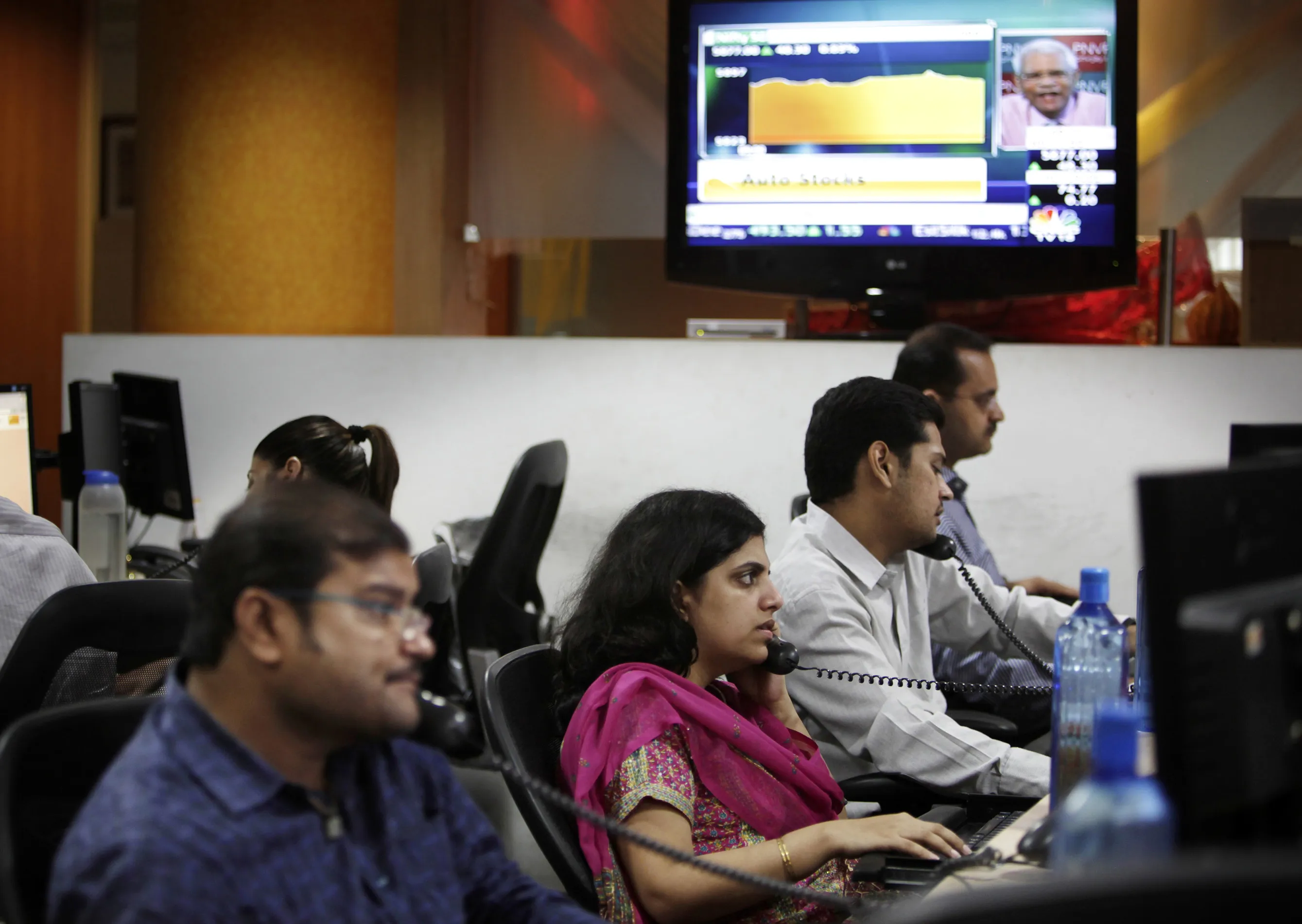 Stock brokers trade at Motival Oswal Securities Ltd. in Mumbai, India, on Saturday, Sept. 18, 2010.