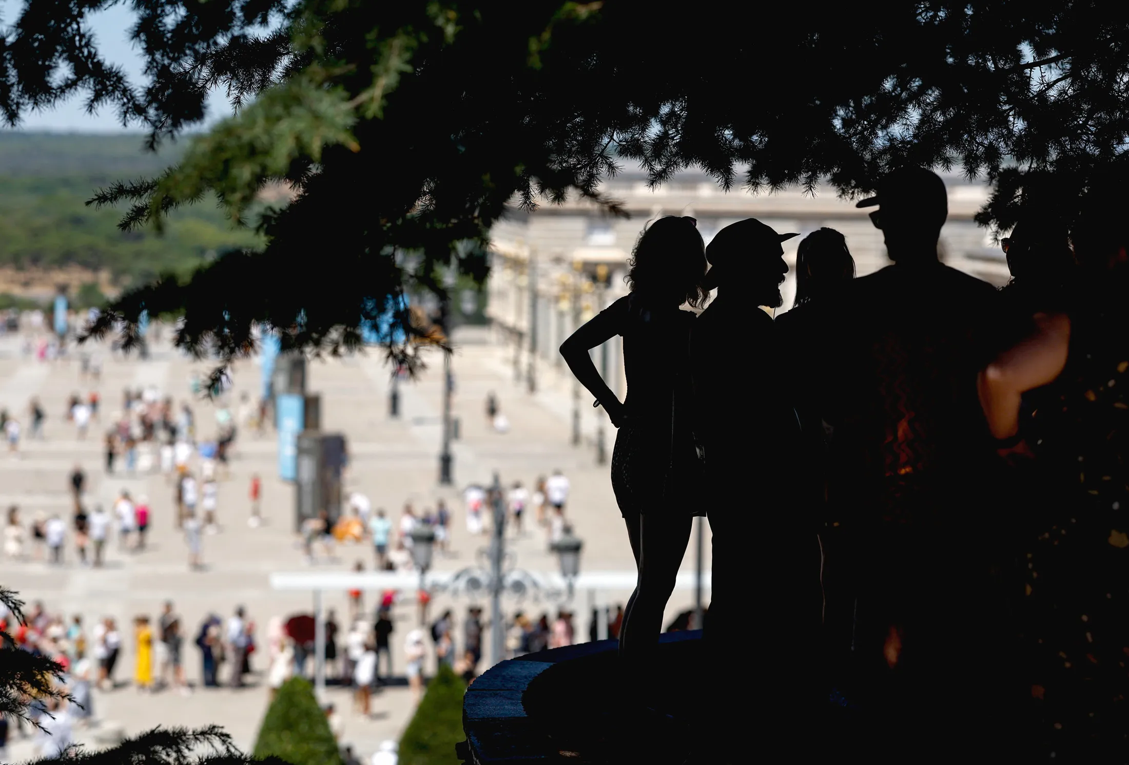 Tourists listen to a tour guide in the shade near the Palacio Real in Madrid, on July 20.