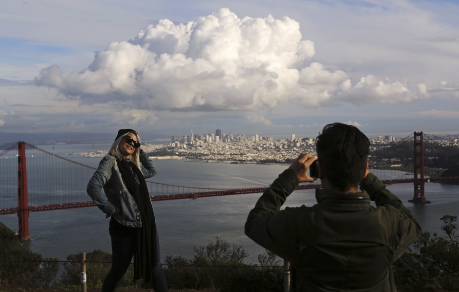 Tourists pose before the iconic skyline of San Francisco. Not seen: the city's soul.
