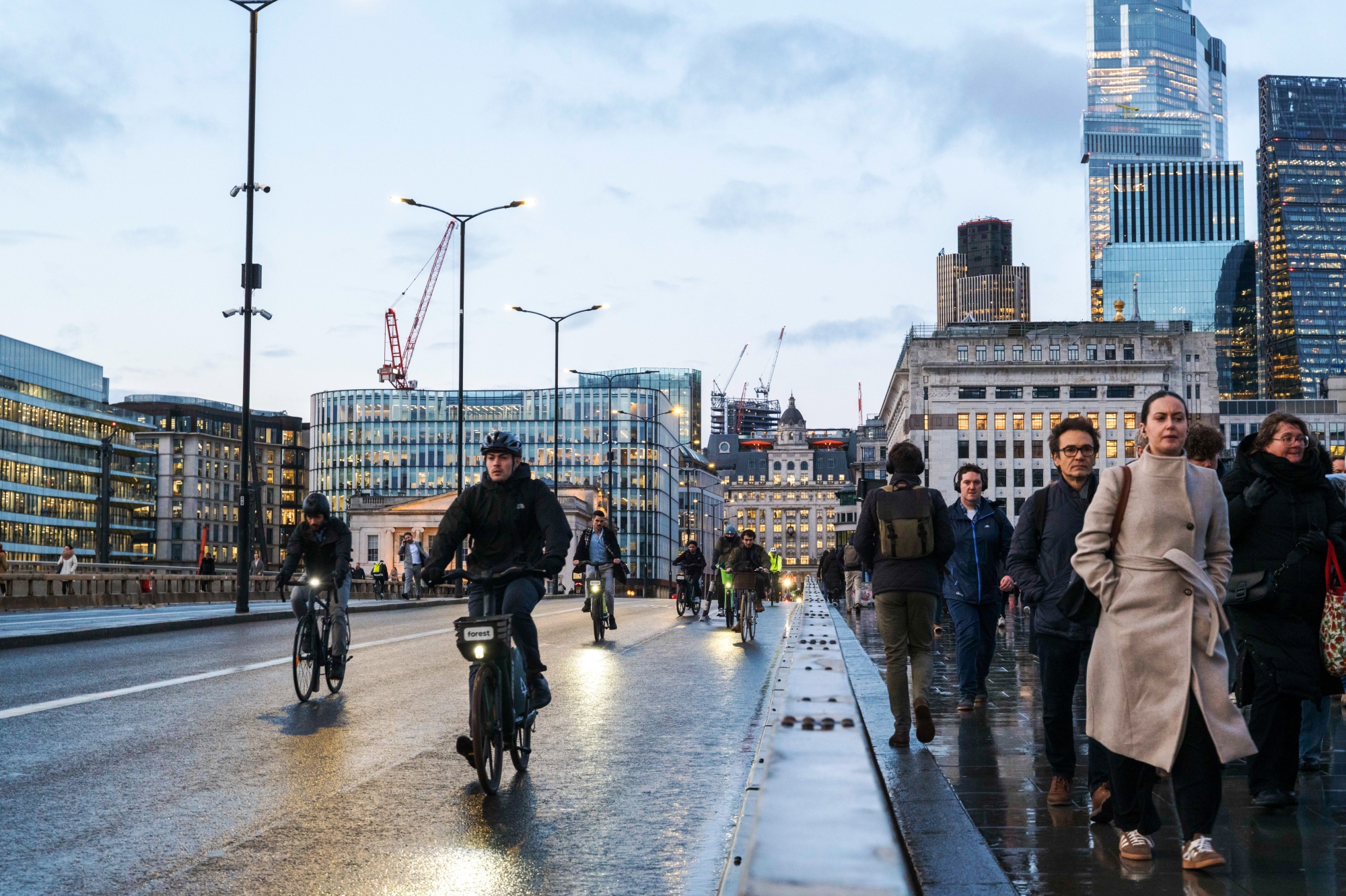 Commuters cross London Bridge in the City of London, UK, on Monday, Feb. 16, 2026. UK unemployment rose to a near five-year high and wage growth eased as the labor market continued to weaken, setting up a potential interest-rate cut by the spring.
