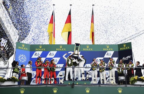 Porche Team Nico Hulkenberg, Earl Bamber, and Nick Tandy celebrate winning the Le Mans 24-Hour race at the Circuit de la Sarthe on June 14, 2015, in Le Mans, France.