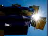 The sun shines behind German artist Ottmar Hoerl 's sculpture depicting the Euro logo outside European Central Bank.