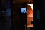 A television screen displays a news conference held by Haruhiko Kuroda, governor of the Bank of Japan.