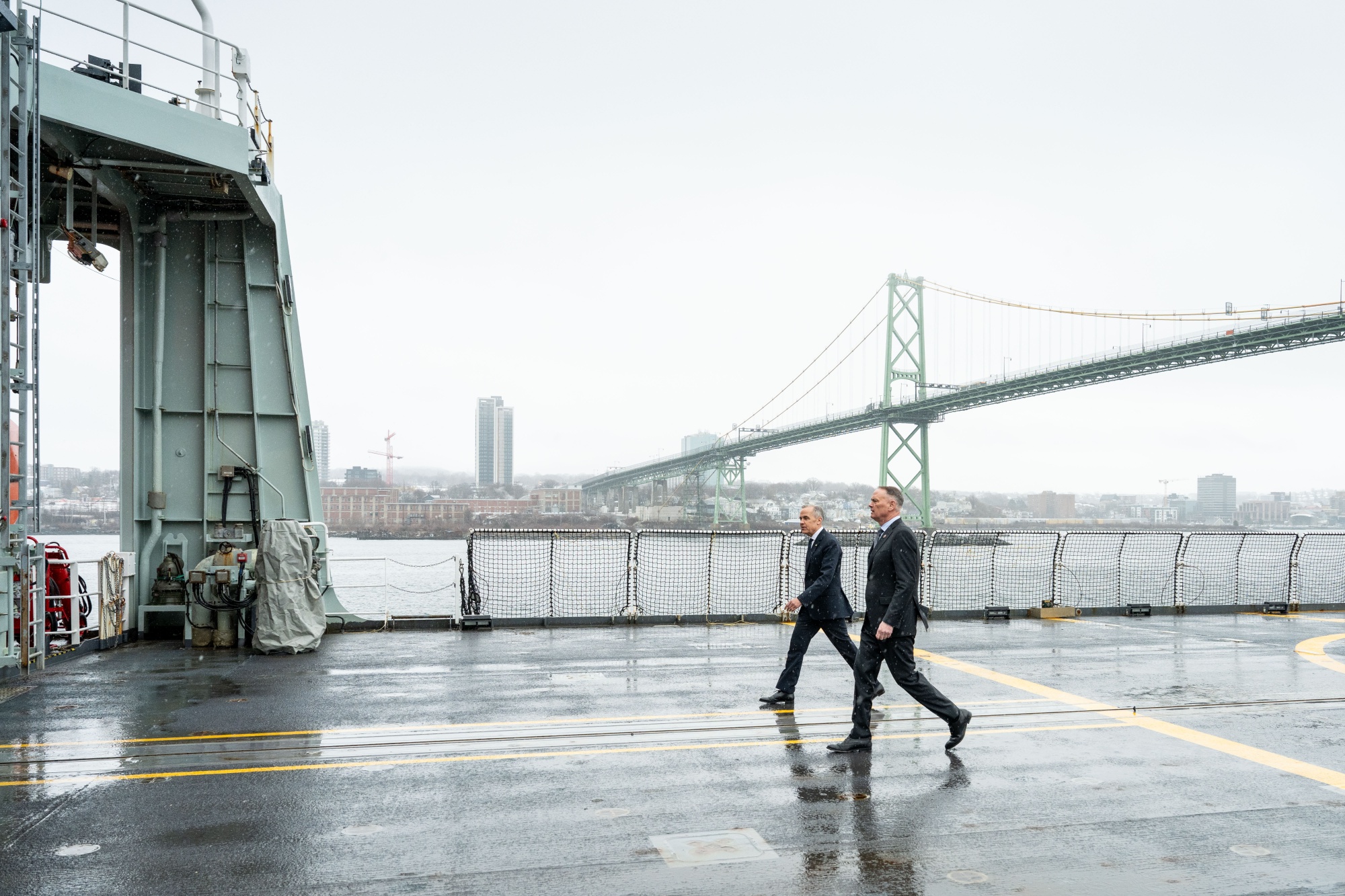 Mark Carney, Canada's prime minister, left, and David McGuinty, Canada's national defense minister, arrive for a news conference at the HMC Dockyard in Halifax, Nova Scotia, Canada, on Thursday, March 26, 2026. Canada hiked its military spending enough in 2025 to reach the target set by the North Atlantic Treaty Organization, fulfilling a promise made by Prime Minister Mark Carney shortly after winning an election last April. Photographer: Dean Casavechia/Bloomberg