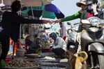A vendor hands money to a motorist as people buy seafood at the Duong Dong market in Phu Quoc, Vietnam.