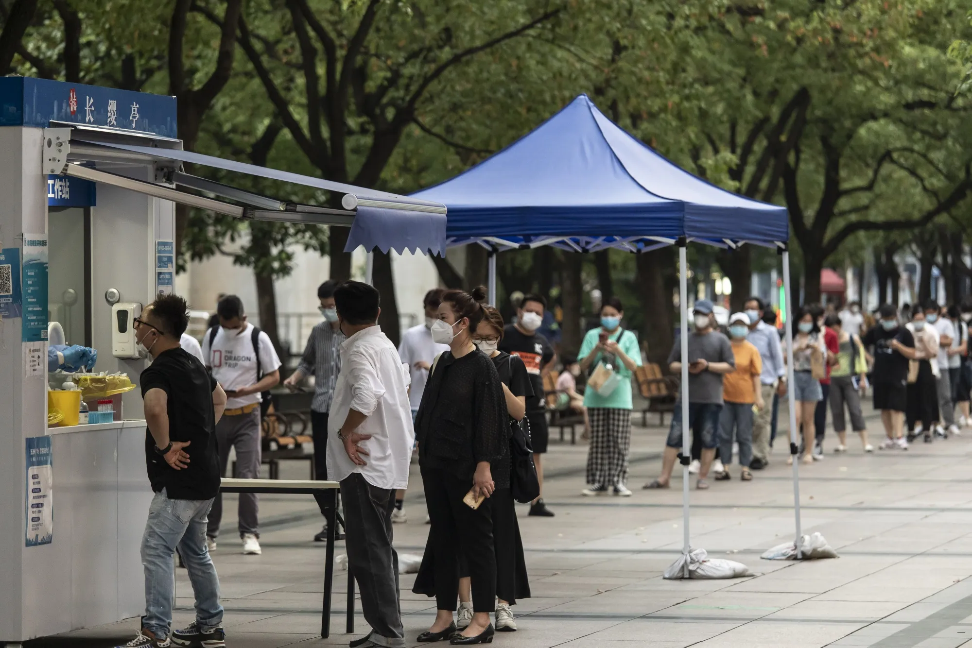 Office workers line up at a Covid-19 testing booth in downtown Shanghai on July 13.