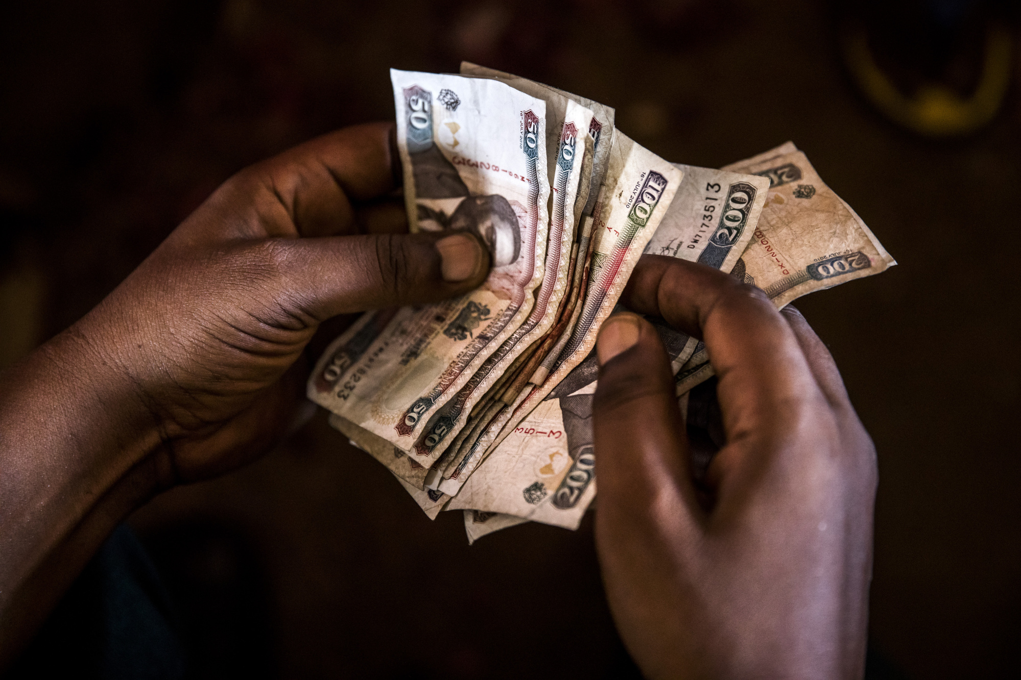 A market trader counts Kenyan shilling banknotes at a market stall in Mombasa, Kenya, on Thursday, Nov. 23, 2017. The country’s Treasury has already cut this year’s growth target to 5 percent from 5.9 percent as the protracted election furor damped investment and a drought curbed farm output. Photographer: Luis Tato/Bloomberg