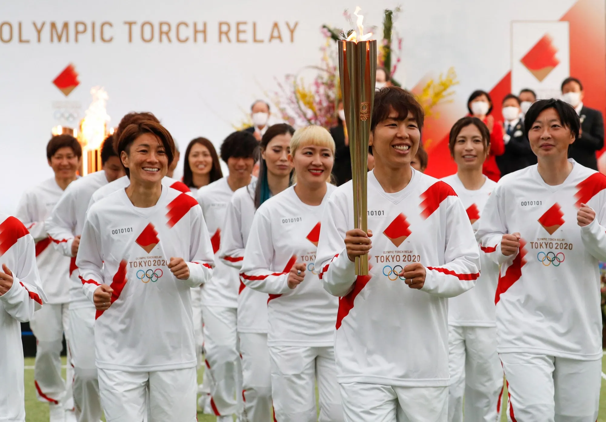 Members of Nadeshiko Japan, women’s national soccer team, start the Olympic torch relay in Naraha, Fukushima, on March 25.
