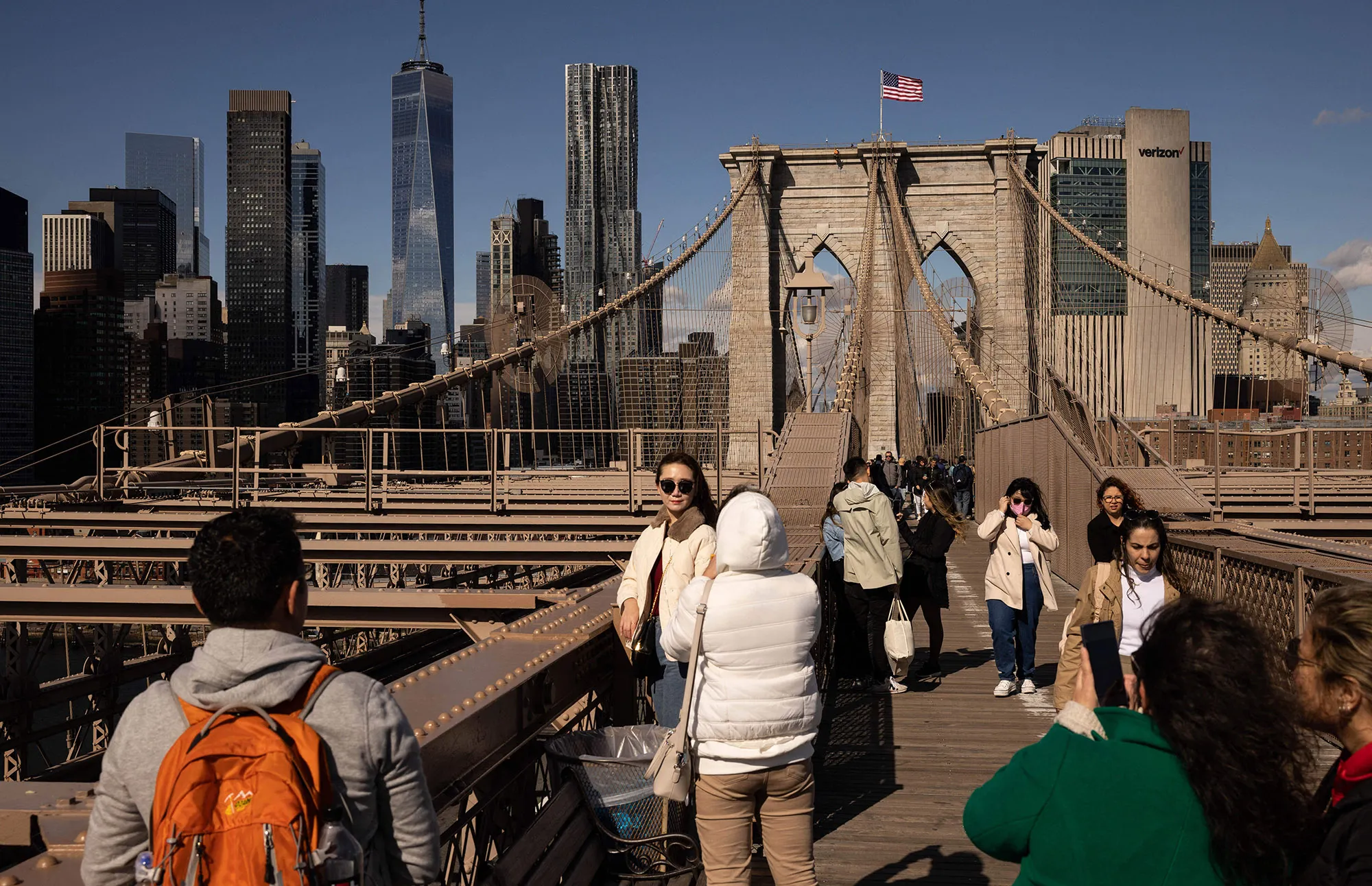 Tourists take photos on the Brooklyn Bridge in New York City.