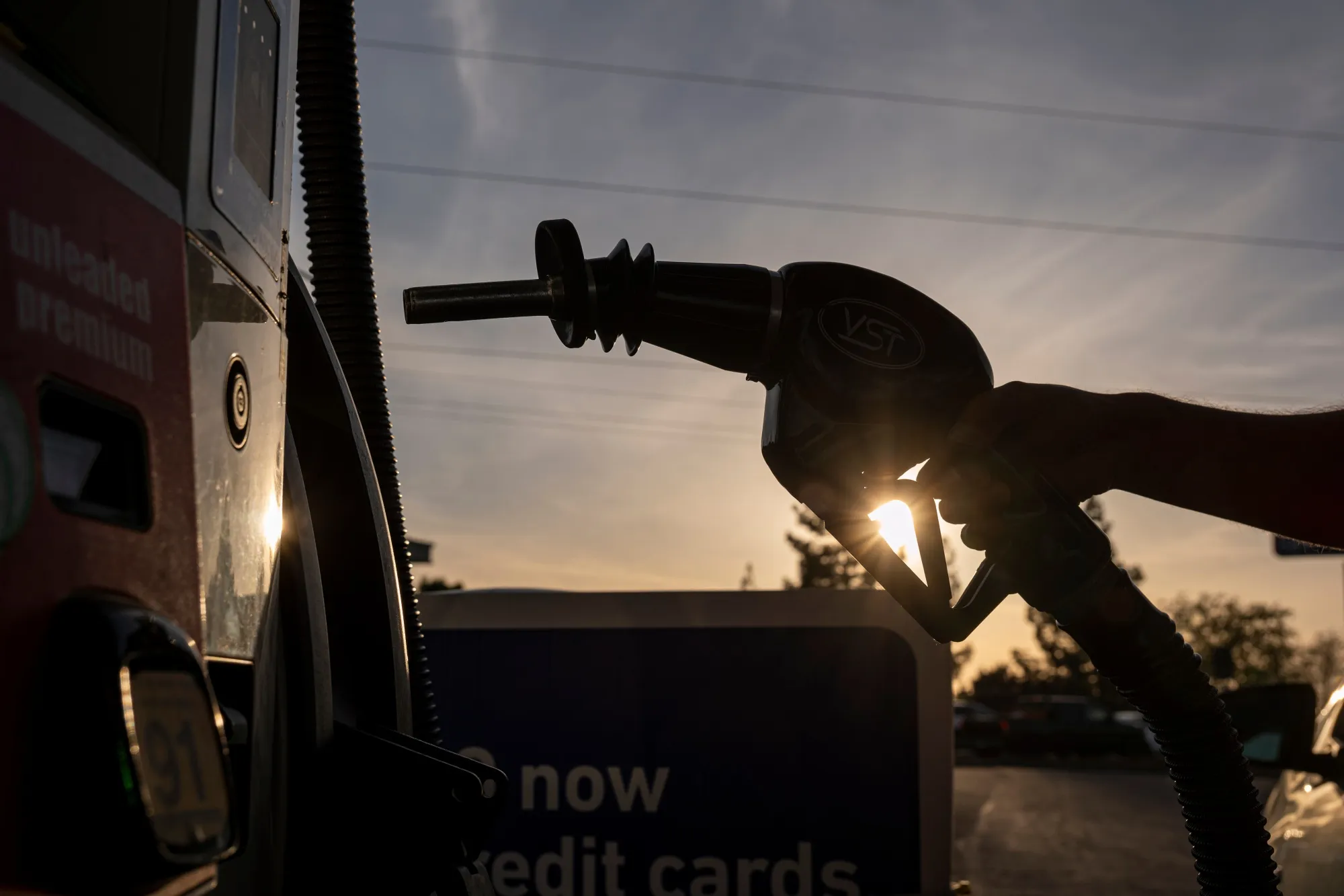 A driver holds a fuel nozzle at a gas station in Sacramento, California.
