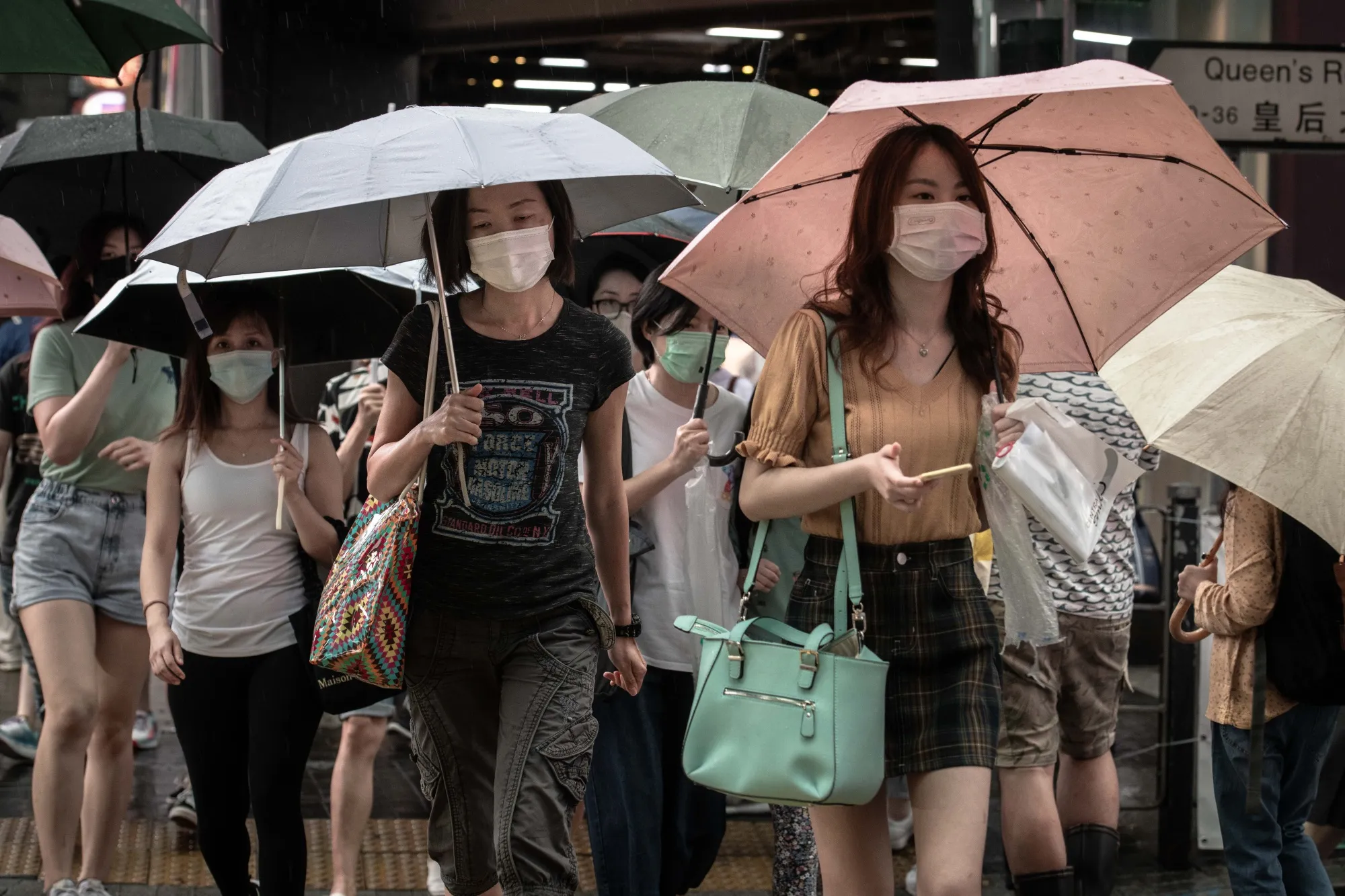 Pedestrians shelter under umbrellas to cross&nbsp;a street in the Central district of&nbsp;Hong Kong, China, on May 30.