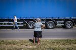 A woman stands in front of a truck parked on BR 040 highway during a protest against rising fuel prices in Luziania, Brazil.