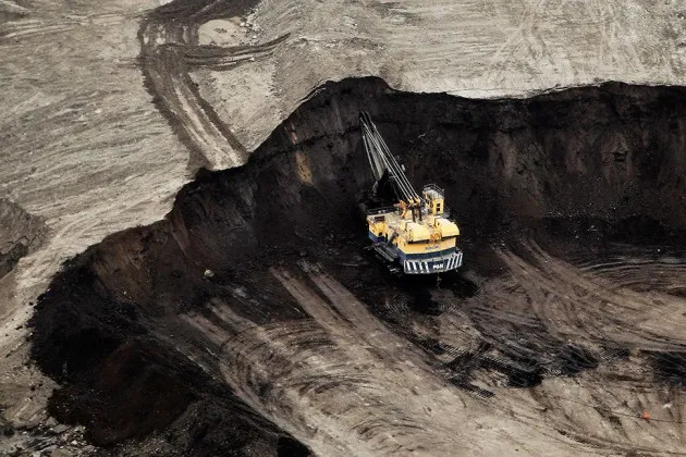 A machine works at the Suncor Energy Inc. mine in this aerial photograph taken above the Athabasca Oil Sands near Fort McMurray, Alberta, Canada.