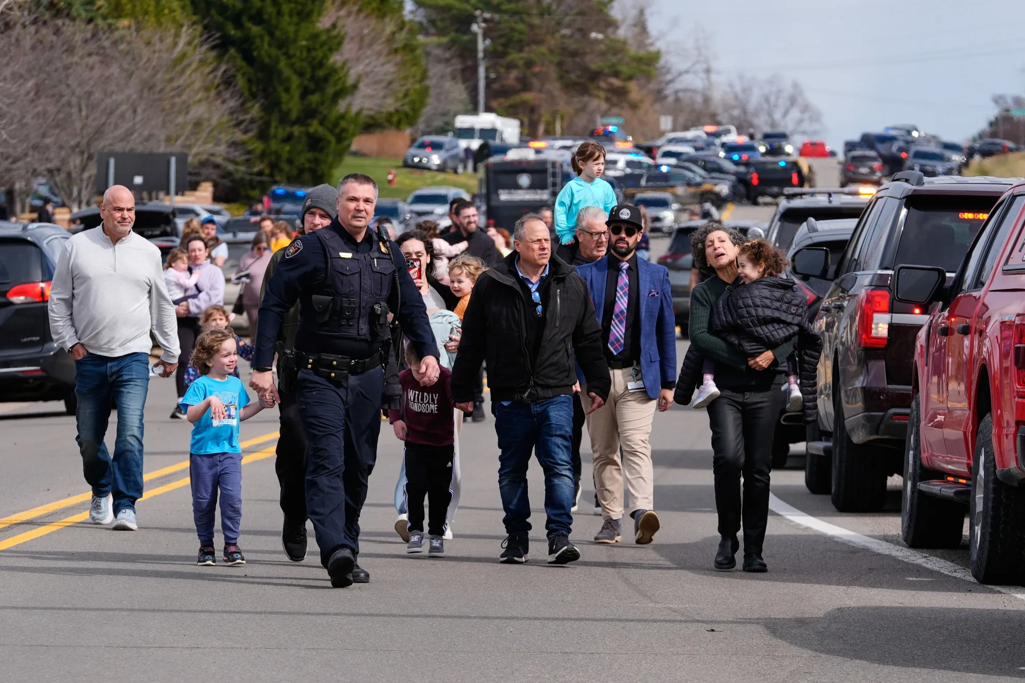 Law enforcement escort families with children away from the Temple Israel synagogue in West Bloomfield Township, Michigan on March 12.