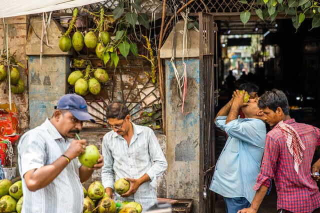 People drinking coconut water at a street stall during a hot summer day in Ahemdabad, Gujarat, India, on Friday, May 6, 2023. Photographer: Prashanth Vishwanathan/Bloomberg