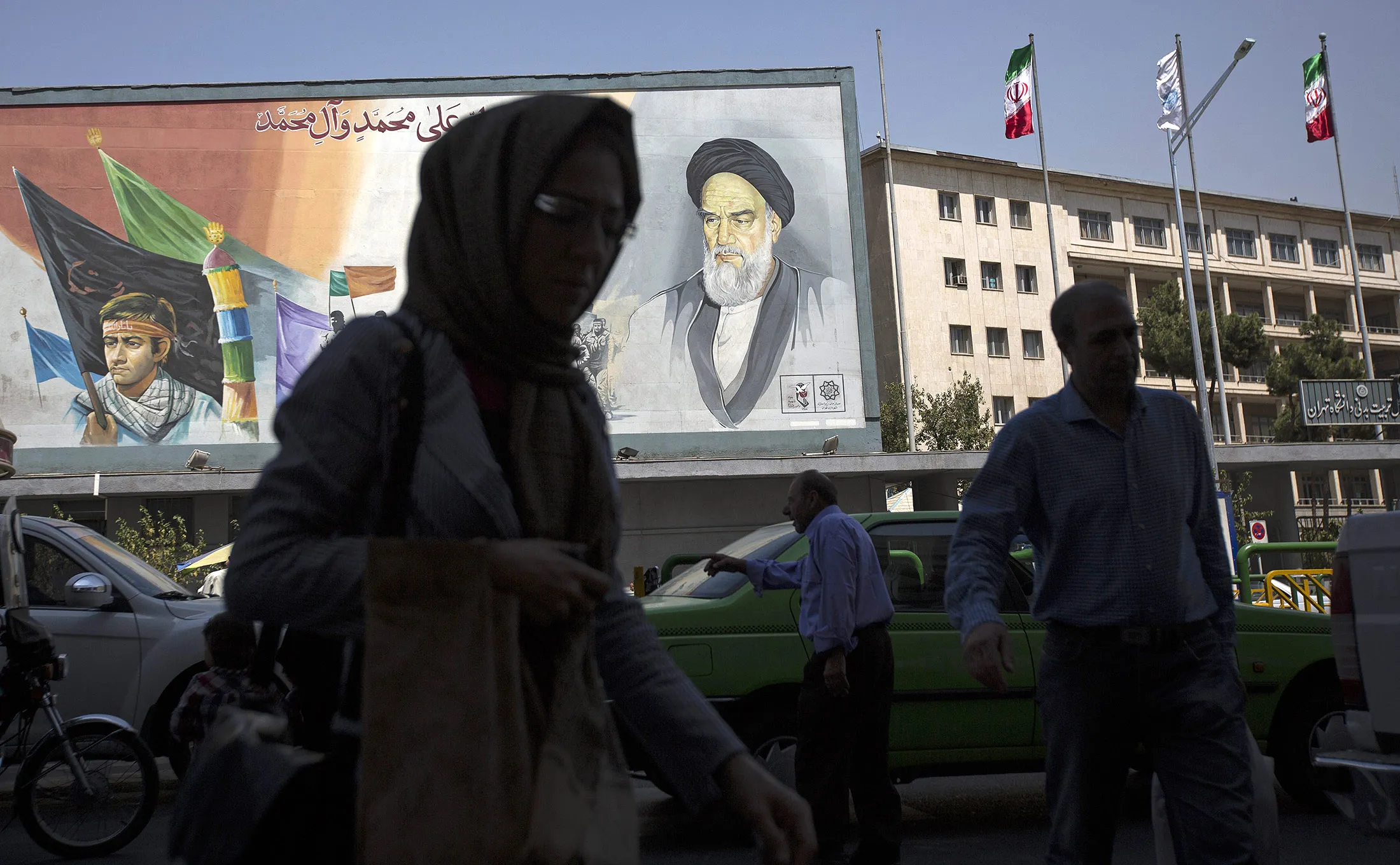Pedestrians pass a giant mural depicting Ruhollah Khomeini, founder of the Islamic republic of Iran, in Tehran, Iran.
