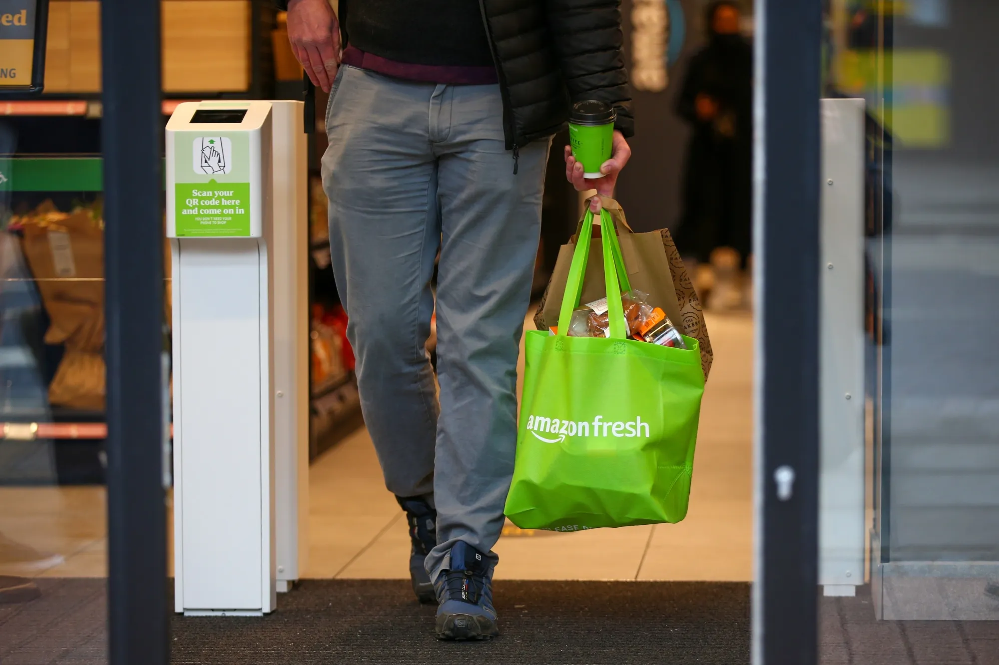 A customer leaves an Amazon Fresh cashierless convenience in London.&nbsp;