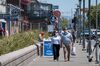 People wearing protective masks walk on Jefferson Street on Fisherman's Wharf in San Francisco, California, U.S.
