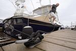 Brad White, of Marshfield, Mass., secures lines for his 33-foot vessel White Cap, at Mill Wharf Marina, Tuesday, Oct. 26, 2021, in Scituate, Mass. Authorities say a powerful autumn storm is bearing down on southern New England, packing potentially damaging winds and threatening to dump as much as six inches of rain in some areas from Tuesday afternoon into Wednesday, Oct. 27. White, a licensed captain, who has been sailing out of Scituate for over 50 years, operates a service called New England Burials At Sea LLC, that provides ash scattering and full body burials at sea. (AP Photo/Steven Senne)