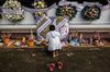 A woman places an offering at a temple to honor those killed in the October 2022 mass slaying at a nearby nursery school in rural Thailand.