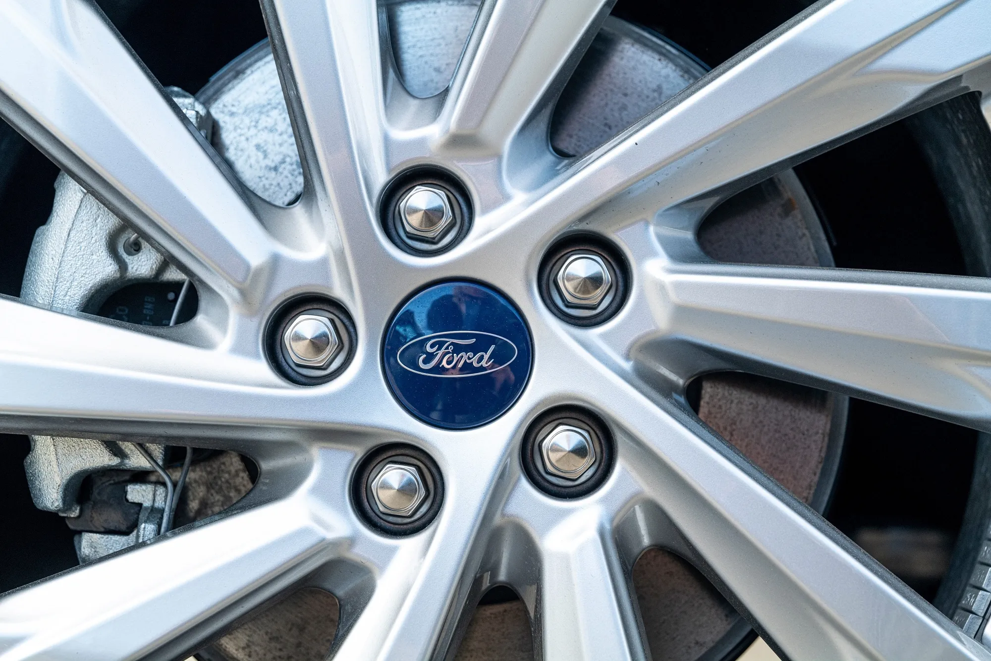 A tire rim on a Ford vehicle.