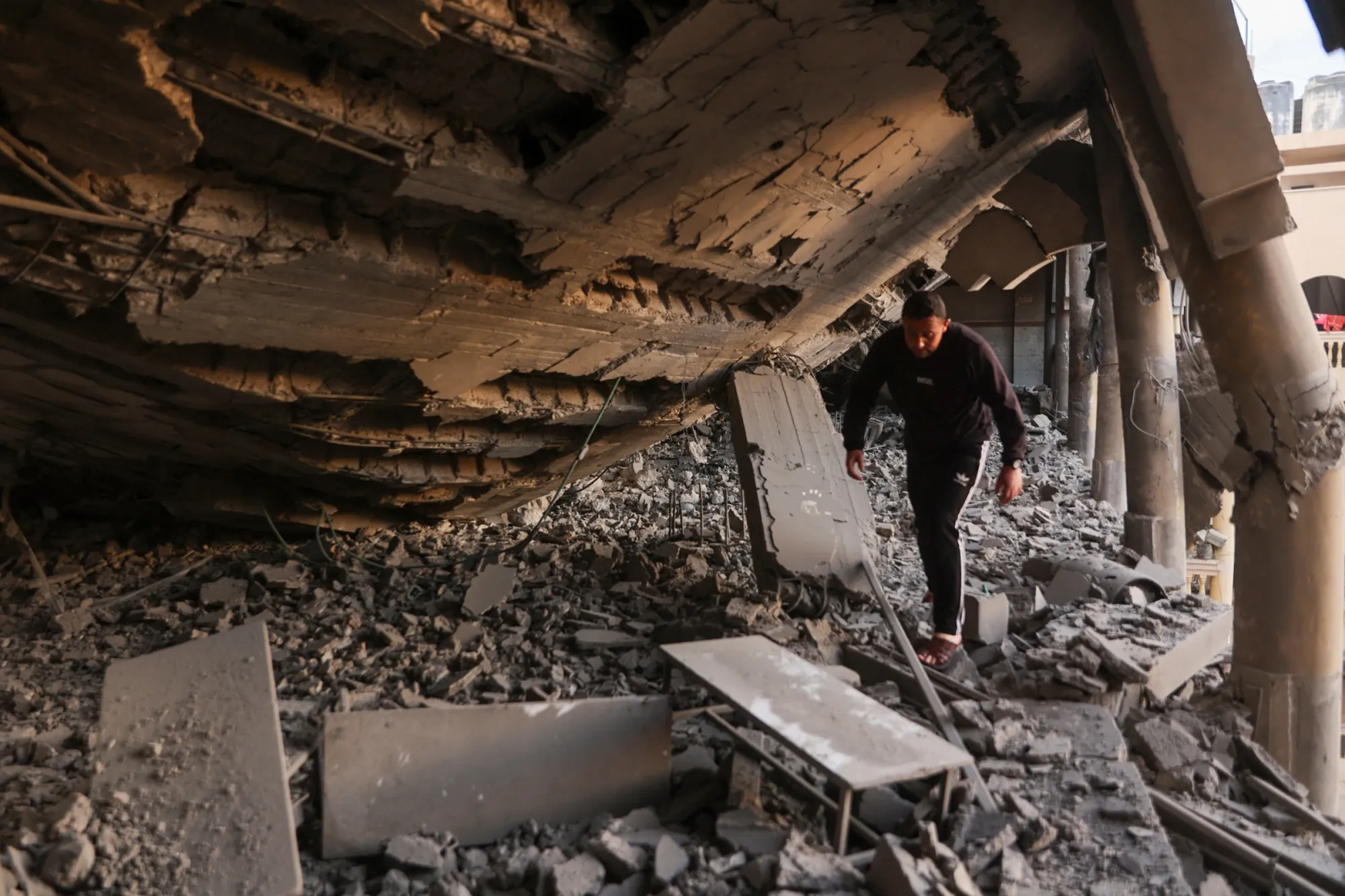 Un hombre camina entre los escombros de una escuela convertida en campamento tras un ataque israelí en Gaza el 18 de marzo.