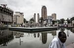 People sit around a disused fountain in the business district of Kinshasa, Democratic Republic of the Congo.