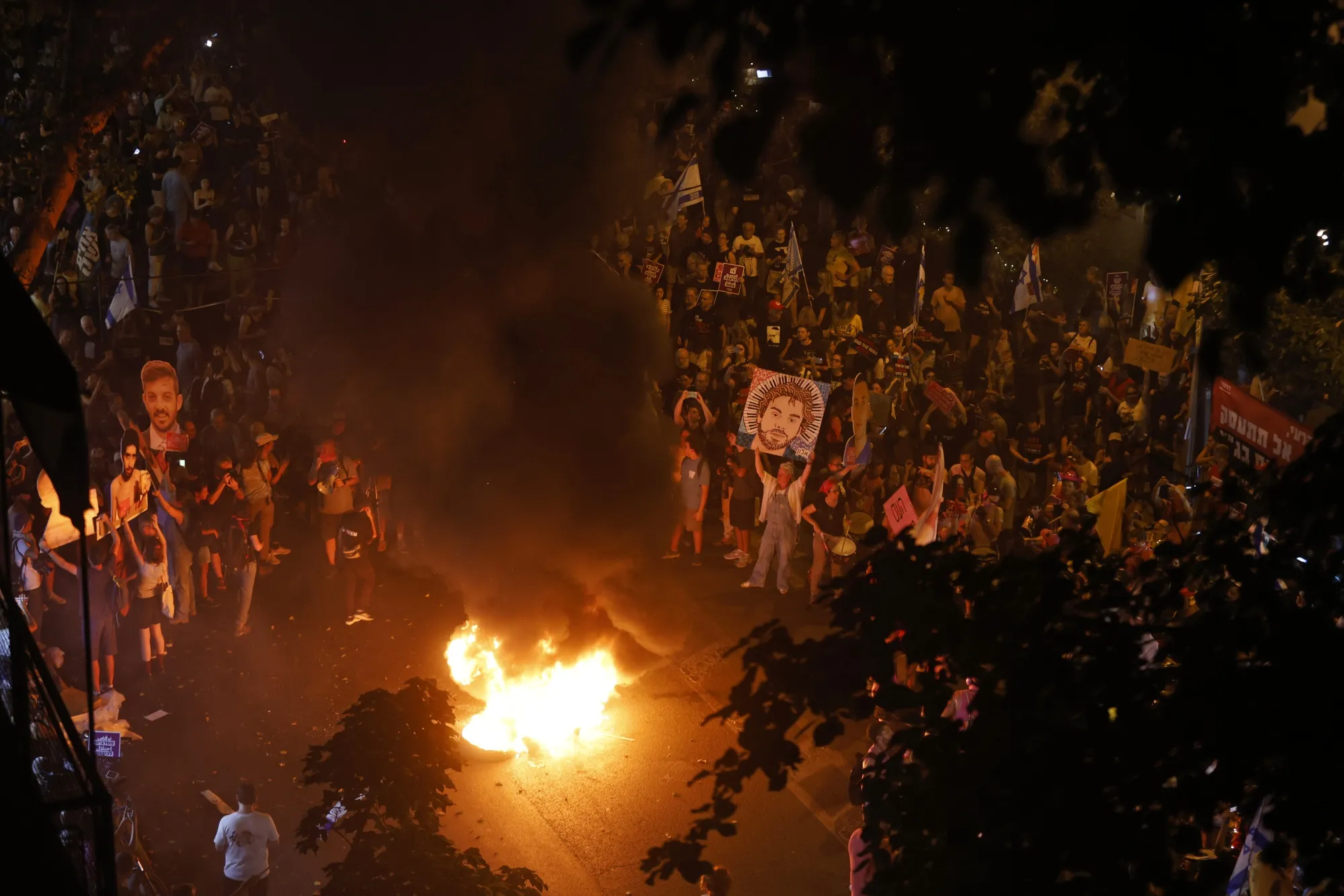 Protesters hold up images of hostages as they gather to demonstrate against Netanyahu's plans to expand occupation in Gaza on August 7, 2025 in Tel Aviv, Israel.