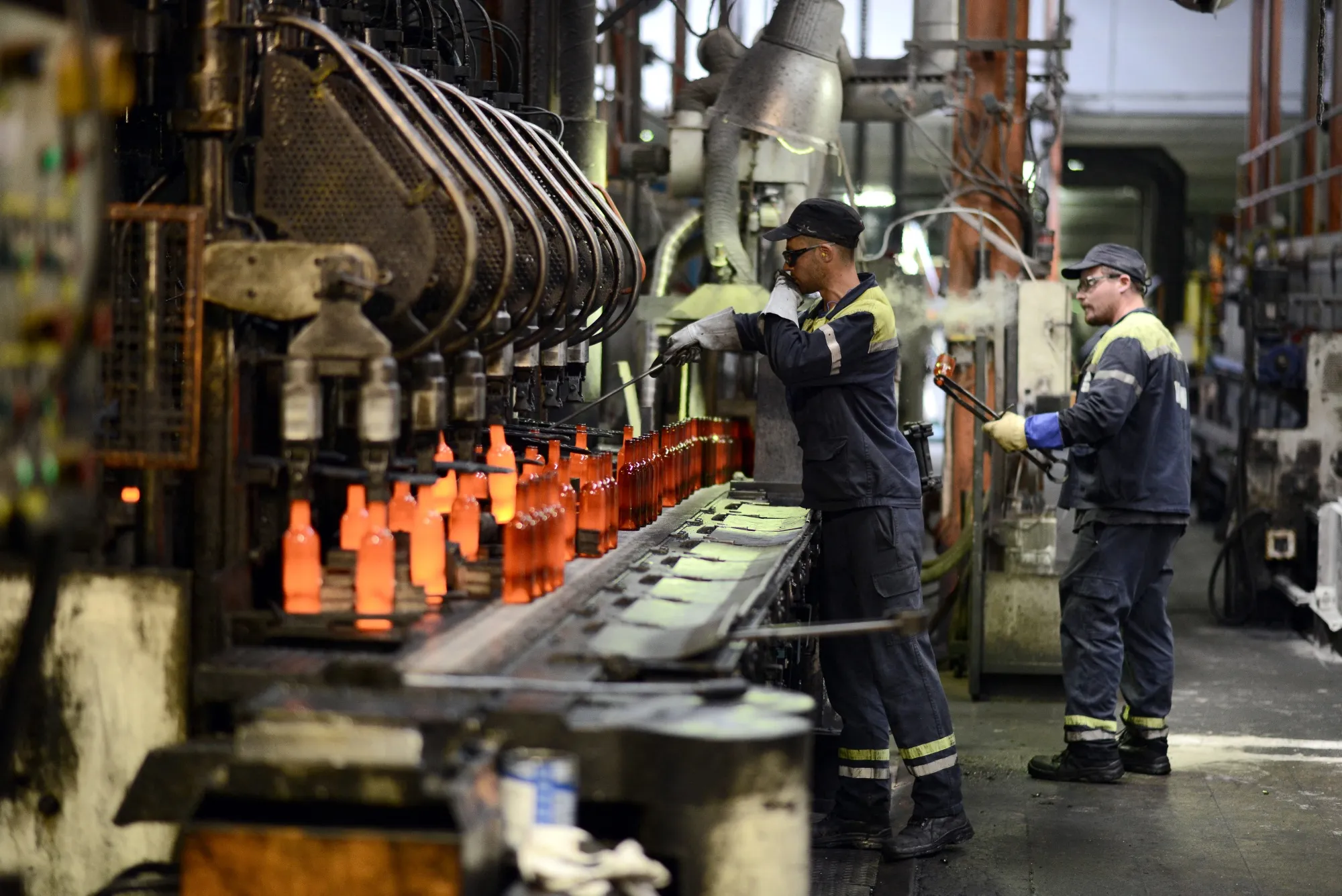 Workers inspect molten glass bottles on a conveyer belt in the glass factory owned by Verallia in Albi, France.&nbsp;