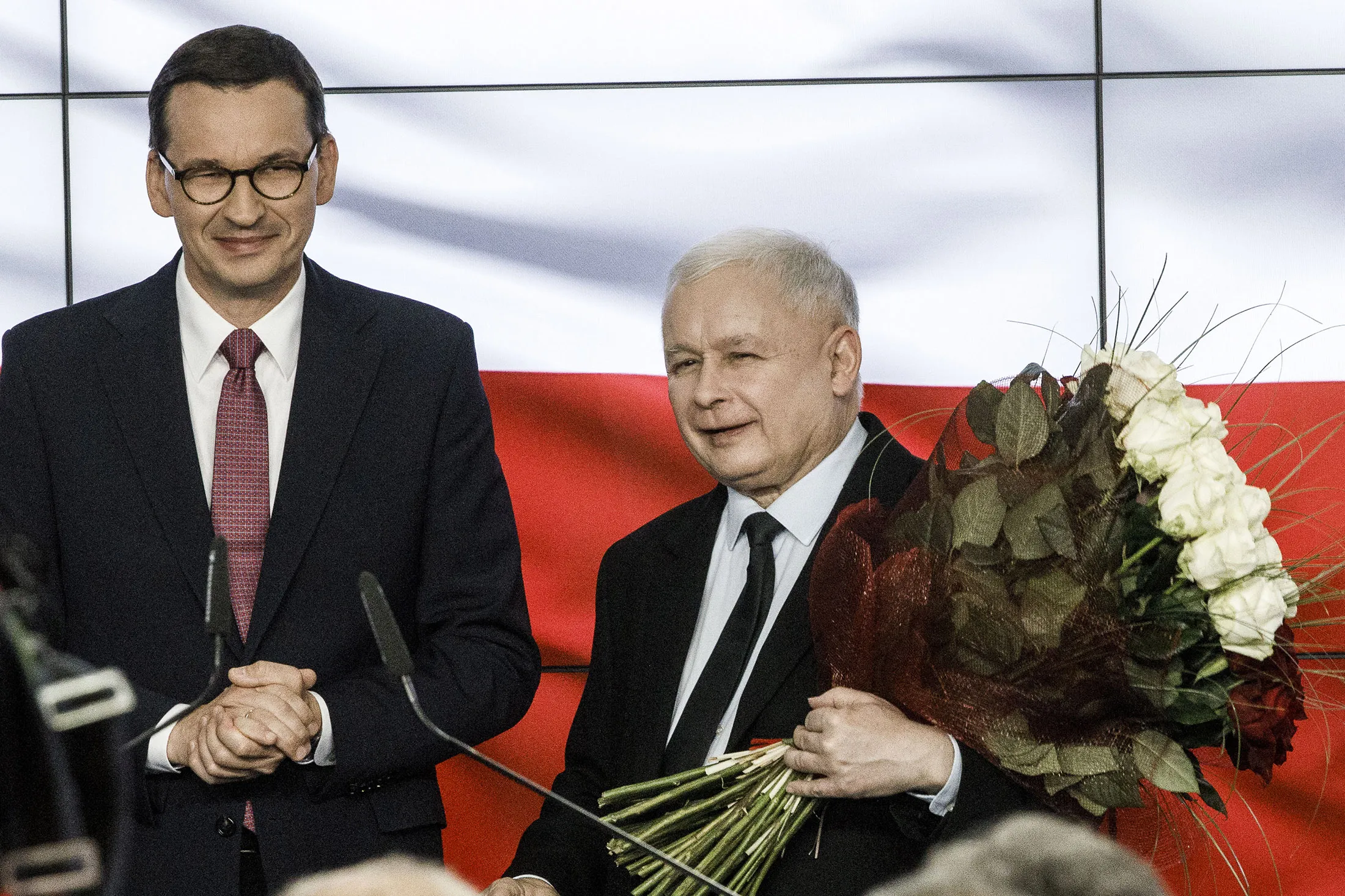 Jaroslaw Kaczynski, right, and Mateusz Morawiecki celebrate the first results in Polish parliamentary elections on Oct. 13.