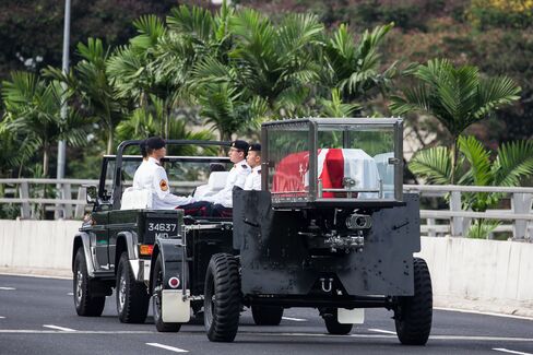 Military personnel carry the coffin bearing the body of Singapore's first elected prime minister Lee Kuan Yew, draped in the Singapore national flag, following his funeral service. Lee Kuan Yew was remembered as the founder of modern Singapore at a state funeral after a procession through the city's streets that drew thousands of mourners despite heavy rain.